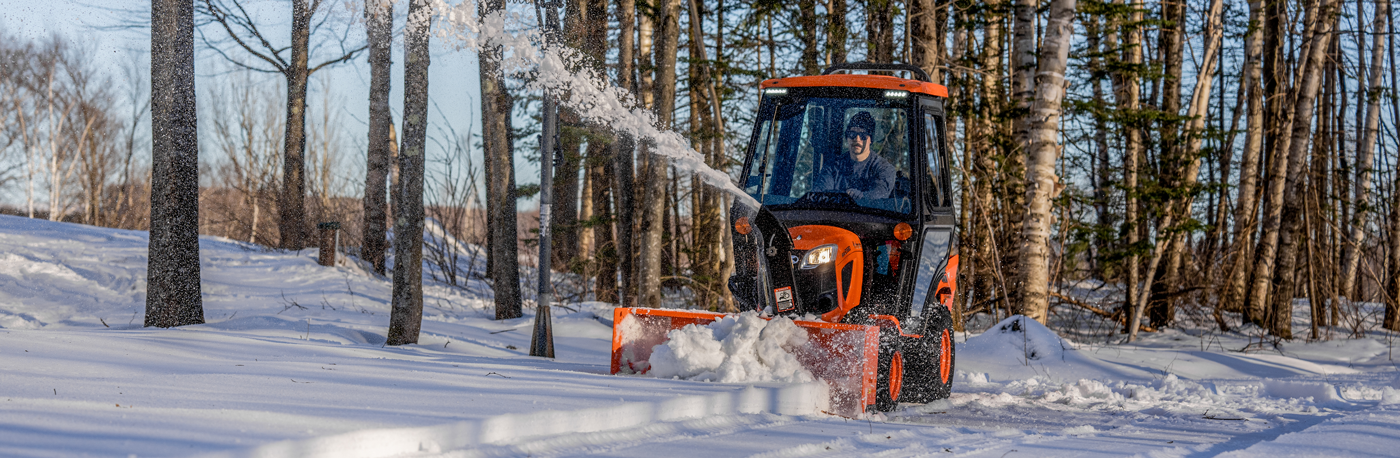 Kubota tractor with front blade sitting in the snow