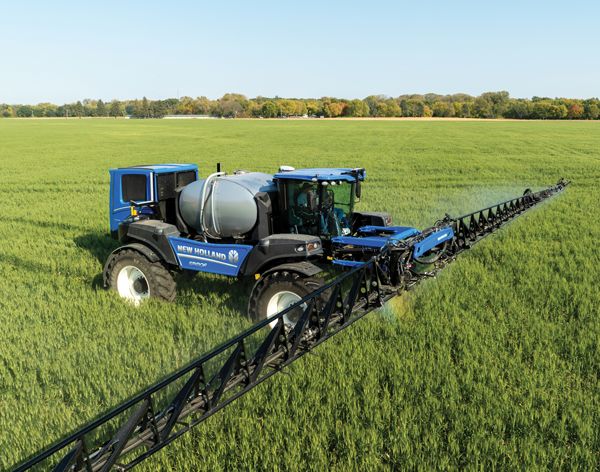 New Holland self-propelled sprayer with extended boom in a field